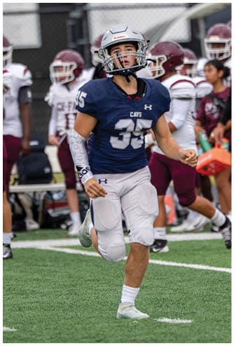 A person wearing a black football helmet and a white Bishop Verot football uniform with the number 17 is holding a football and appears focused on the game. Descripci n generada con IA