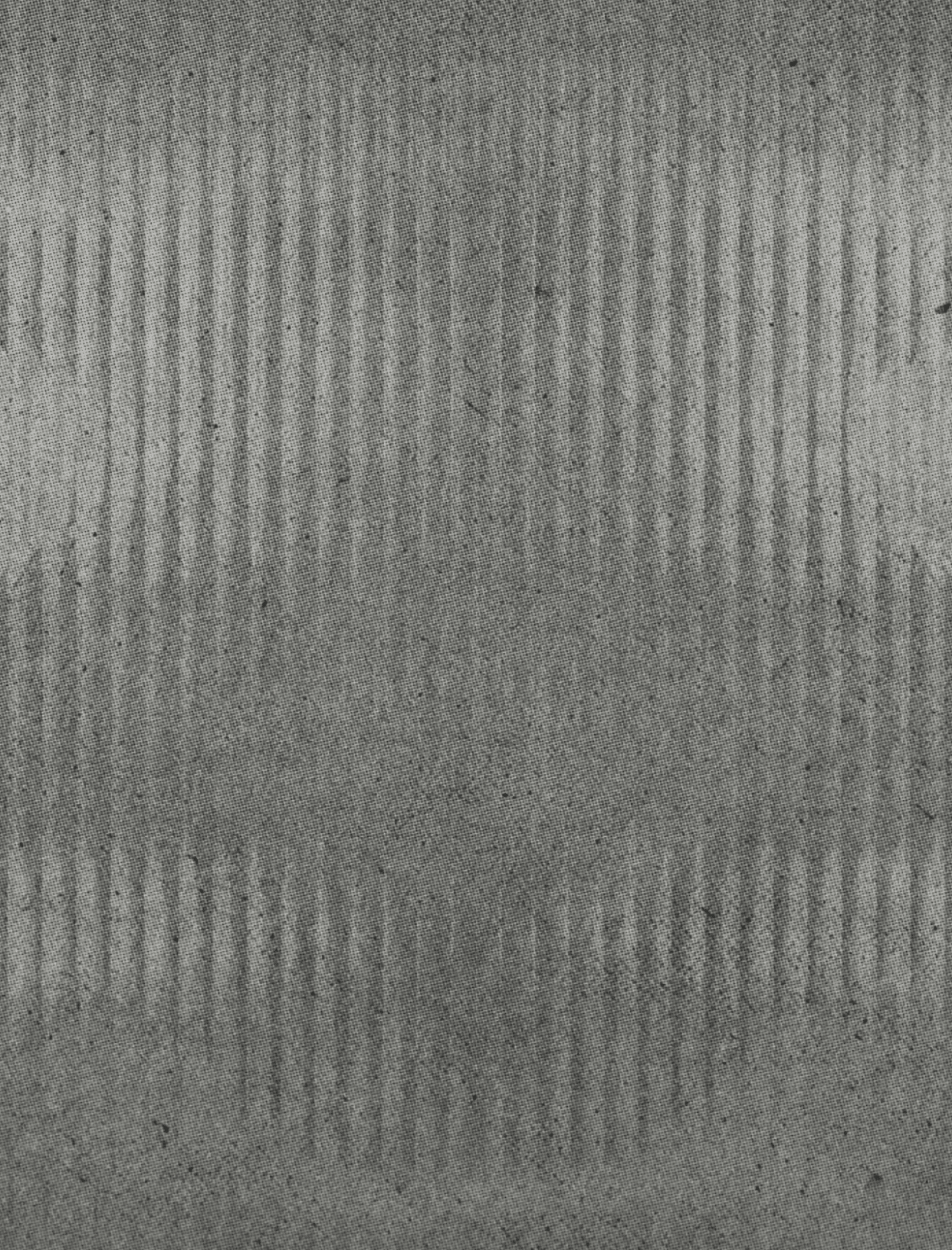 A textured surface with a symmetrical pattern of vertical lines creating a subtle geometric design. Descripci n generada con IA