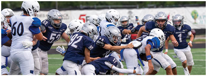 Two opposing American football teams in green and white uniforms are lined up on a field preparing for the next play. Descripci n generada con IA