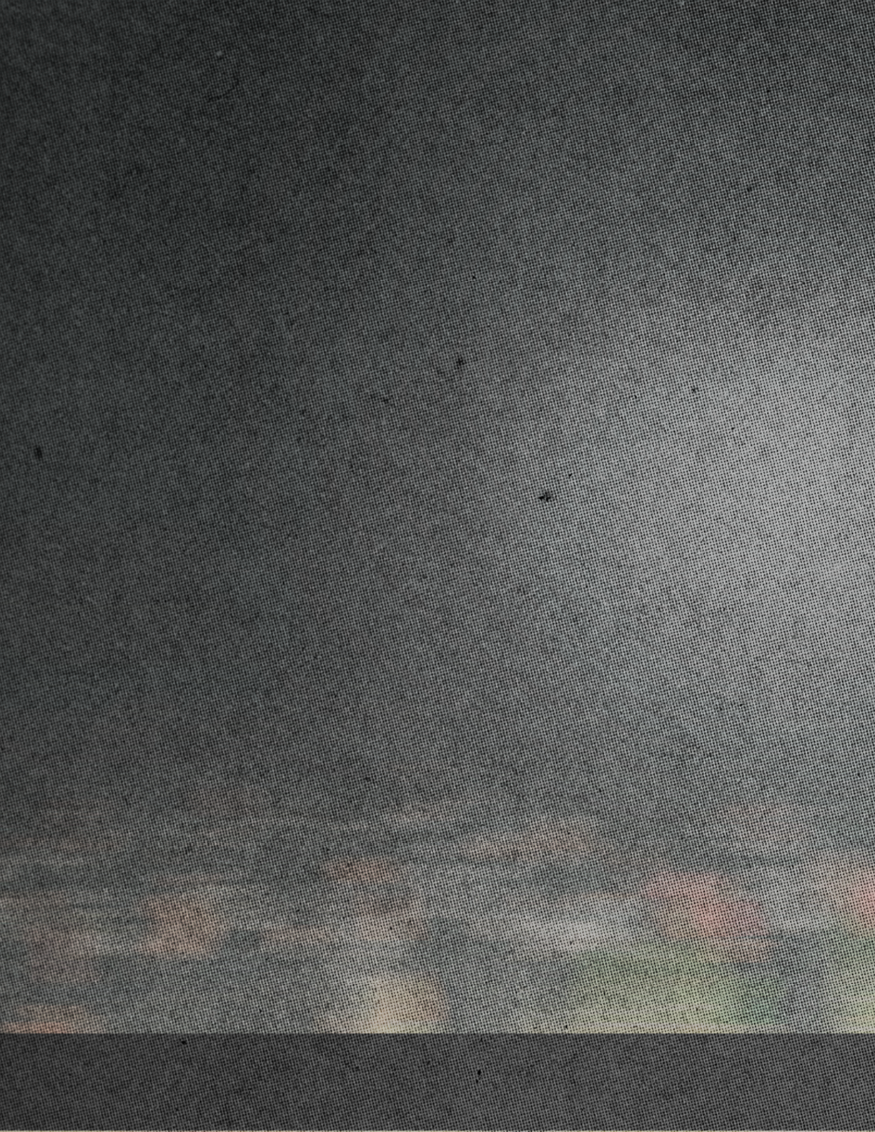 A dark textured surface with a faint, blurry horizontal band of muted colors near the bottom. Descripci n generada con IA