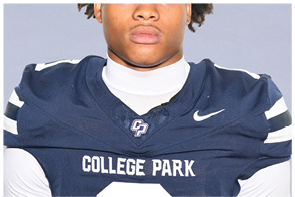 A person wearing a navy blue football jersey with white stripes on the shoulders and the words “COLLEGE PARK" printed on the front. Descripci n generada con IA