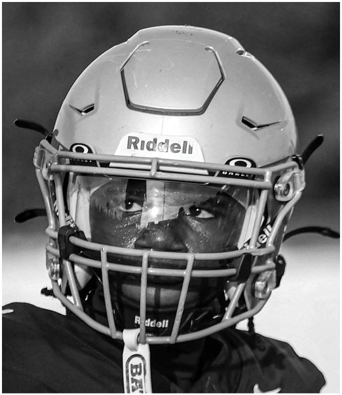 A close-up of a white football helmet with ventilation holes and part of a faceguard visible. Descripci n generada con IA