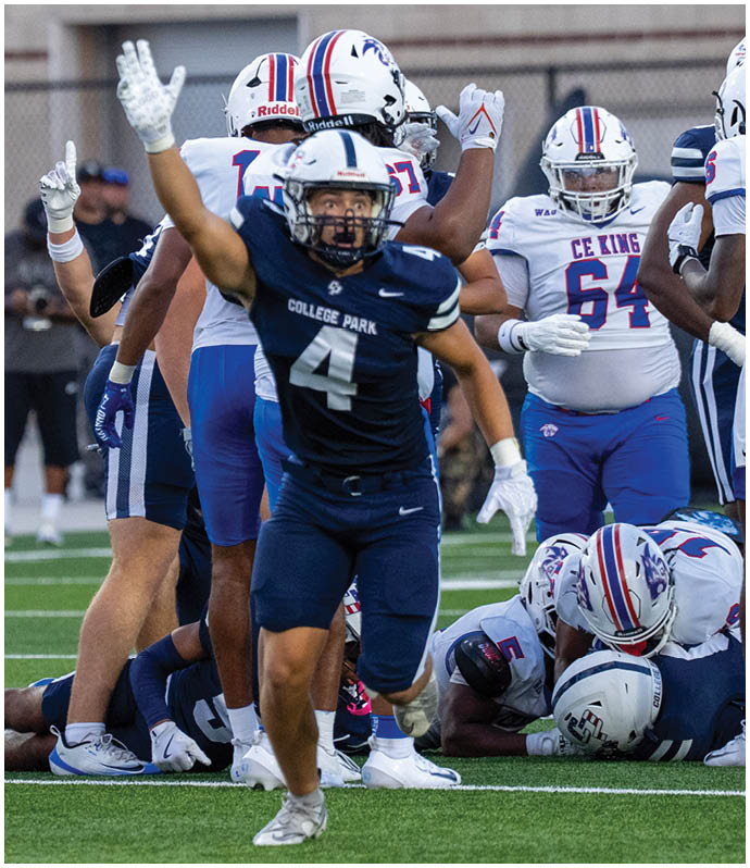 A group of football players in blue and white uniforms are on a field with one player in a dark blue uniform raising their arms in celebration while others are gathered around a pile on the ground. Descripci n generada con IA