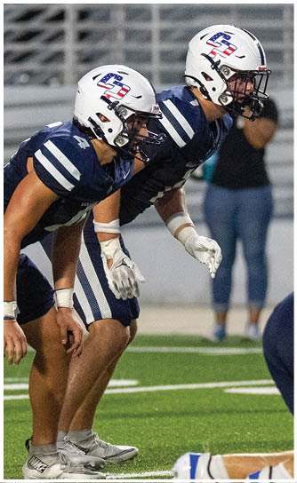 A person wearing a navy blue football uniform with the number 24 and the words College Park on the chest is on a field, wearing a white helmet with a blue stripe and a green mouthguard. Descripci n generada con IA