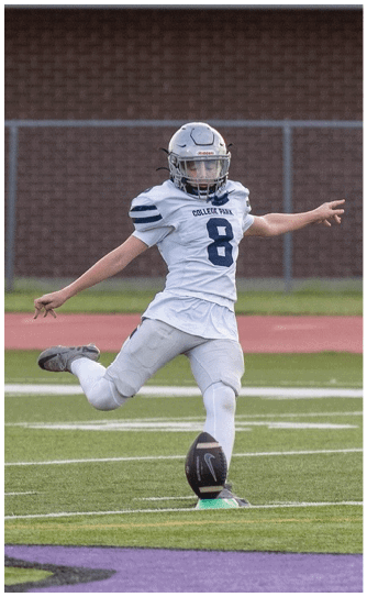 A person wearing a black football helmet and a white Bishop Verot jersey with the number 17 is raising their arms. Descripci n generada con IA