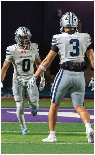 A person wearing a navy blue football uniform with the number 24 and the words College Park on the chest is on a field, wearing a white helmet with a blue stripe and a green mouthguard. Descripci n generada con IA