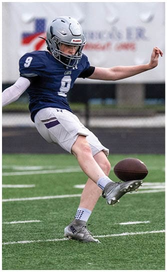 A person wearing a blue football uniform with the number nine and a silver helmet is in action on a football field. Descripci n generada con IA