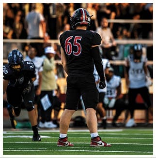 A football player wearing a blue and red jersey. Description generated by AI