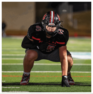 A football player wearing a blue and red jersey. Description generated by AI
