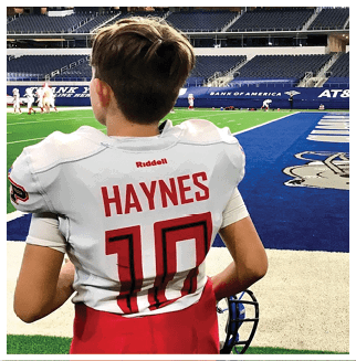 A football player wearing a blue and red jersey. Description generated by AI