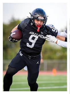 Two football players wearing black jerseys and holding hands. Description generated by AI