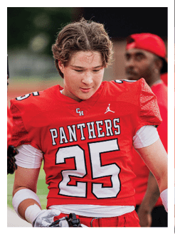 Two football players wearing black jerseys and holding hands. Description generated by AI