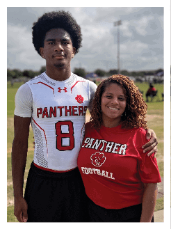 Two football players wearing black jerseys and holding hands. Description generated by AI