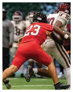 A football player wearing a blue and red jersey. Description generated by AI