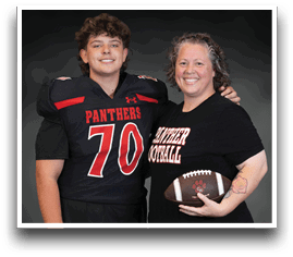 A person wearing a football uniform with the number 70 stands next to another person holding a football and wearing a shirt that says “Panther Football," both smiling against a dark background. Description generated by AI