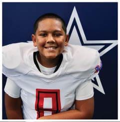 A football player wearing a blue and red jersey. Description generated by AI