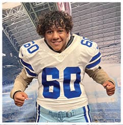 A football player wearing a blue and red jersey. Description generated by AI