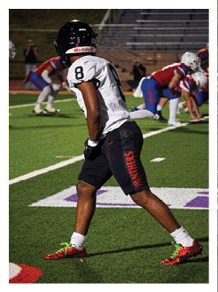 Two football players wearing black jerseys and holding hands. Description generated by AI