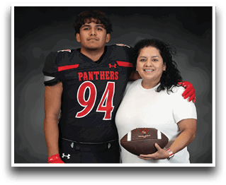 A person wearing a black football uniform with the number 94 and the word Panthers stands with an arm around another person in a white shirt holding a football, both smiling against a dark background. Description generated by AI
