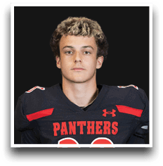 Person with curly hair wearing a black and red football jersey with the word Panthers on the front. Description generated by AI
