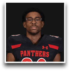 Person wearing glasses and a black football jersey with red accents and the word “PANTHERS" on the front. Description generated by AI