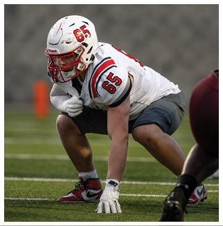A football player wearing a blue and red jersey. Description generated by AI