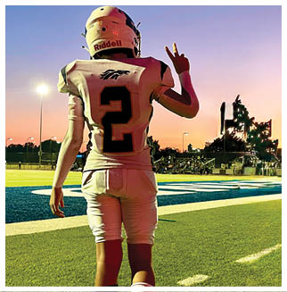 A football player wearing a blue and red jersey. Description generated by AI
