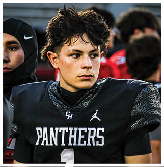 A football player wearing a blue and red jersey. Description generated by AI