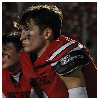 A football player wearing a blue and red jersey. Description generated by AI