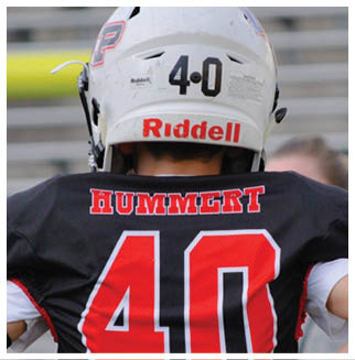 A football player wearing a blue and red jersey. Description generated by AI