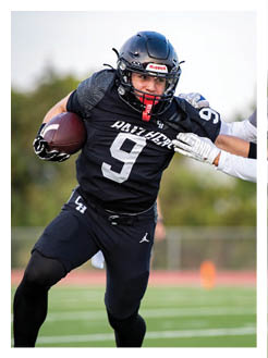 Two football players wearing black jerseys and holding hands. Description generated by AI