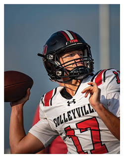 A football player wearing a blue and red jersey. Description generated by AI