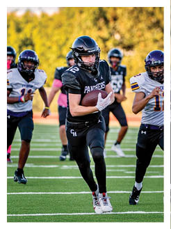 Two football players wearing black jerseys and holding hands. Description generated by AI