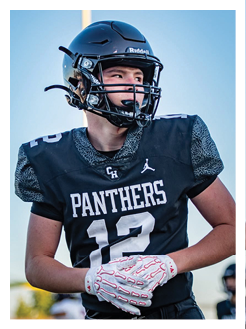 Two football players wearing black jerseys and holding hands. Description generated by AI