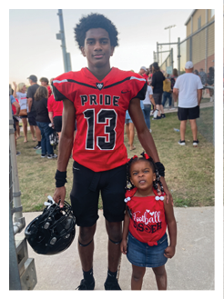 Two football players wearing black jerseys and holding hands. Description generated by AI