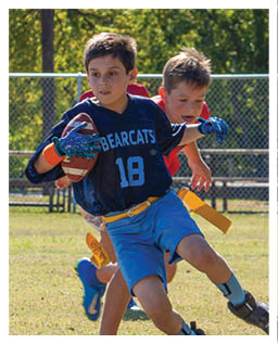 A football player wearing a blue and red jersey. Description generated by AI