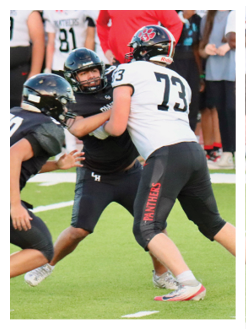 Two football players wearing black jerseys and holding hands. Description generated by AI
