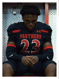 Two football players wearing black jerseys and holding hands. Description generated by AI