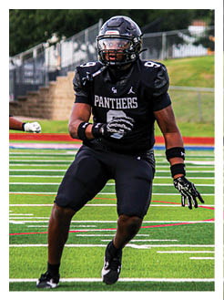Two football players wearing black jerseys and holding hands. Description generated by AI