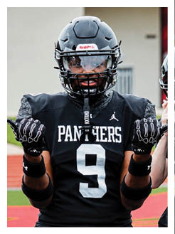 Two football players wearing black jerseys and holding hands. Description generated by AI