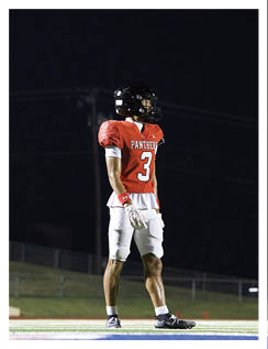 A football player wearing a blue and red jersey. Description generated by AI