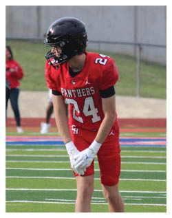 A football player wearing a blue and red jersey. Description generated by AI