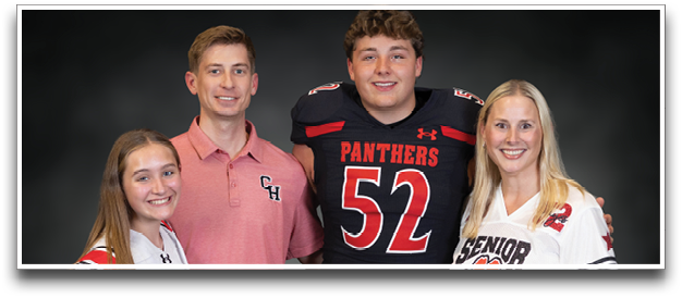 Four people wearing sports jerseys and holding footballs stand together smiling against a dark background. Description generated by AI
