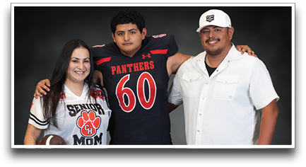 Three people stand together with one person wearing a sports jersey holding a football, another in a football uniform, and the third in a white button-up shirt. Description generated by AI