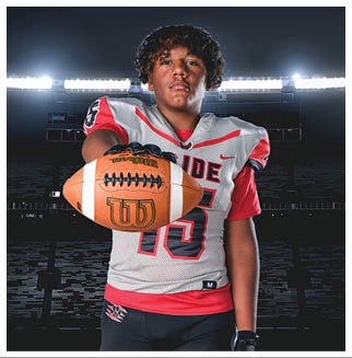 A football player wearing a blue and red jersey. Description generated by AI