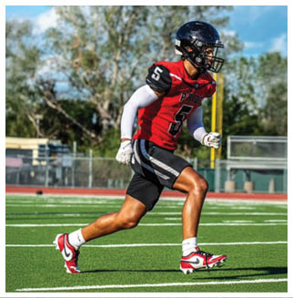 A football player wearing a blue and red jersey. Description generated by AI