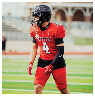 A football player wearing a blue and red jersey. Description generated by AI