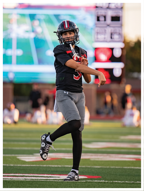 Two football players wearing black jerseys and holding hands. Description generated by AI