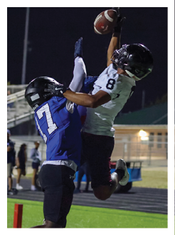 Two football players wearing black jerseys and holding hands. Description generated by AI