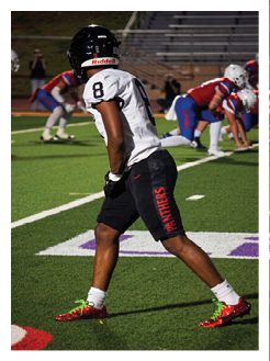 Two football players wearing black jerseys and holding hands. Description generated by AI